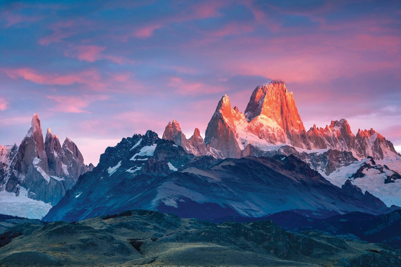 Snow-capped mountain peaks glowing at sunset