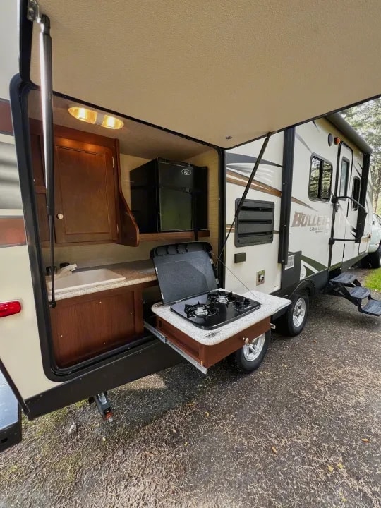 Side view of the trailer with the outdoor kitchen compartment open