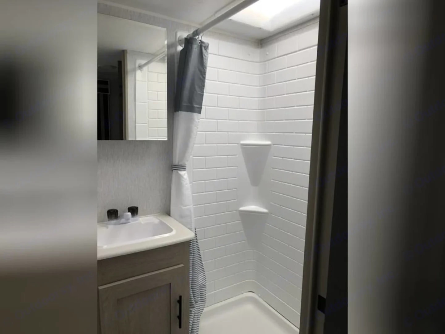 Bathroom with subway-tile shower stall, curtain, sink, and mirror