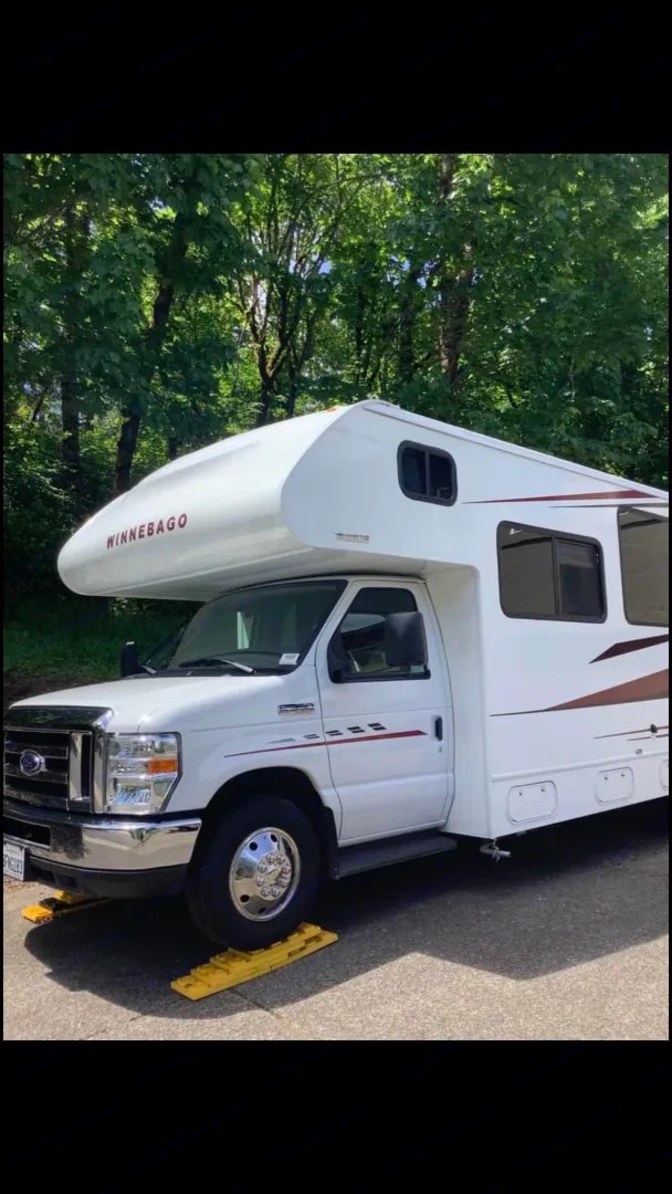 Exterior side view of the motorhome parked under trees