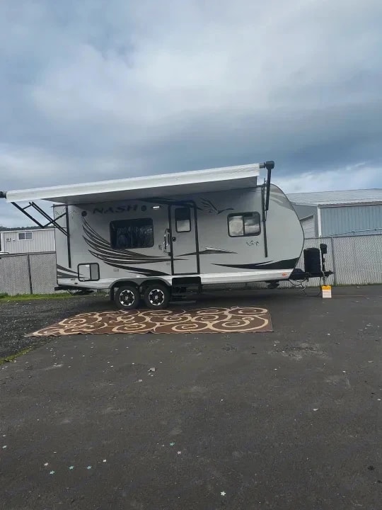 Three-quarter exterior view with awning extended and NASH graphics on the side
