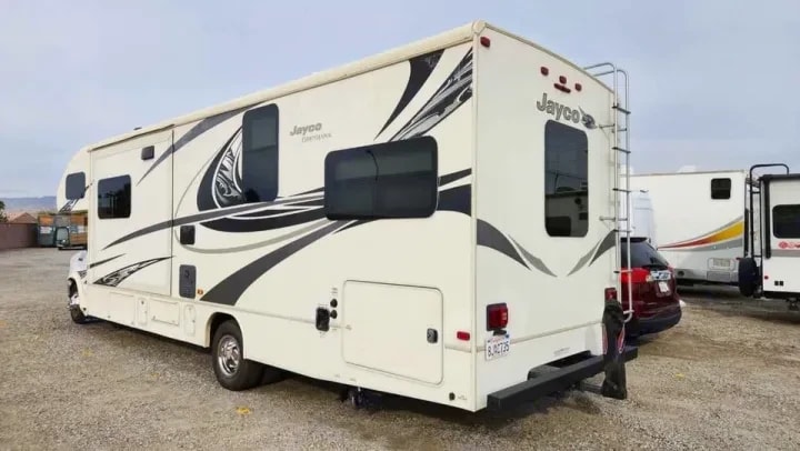 Rear three-quarter exterior view of the Jayco Greyhawk in a gravel lot