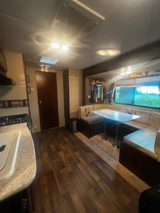 Wide interior view of the kitchen counter and booth dinette by the window
