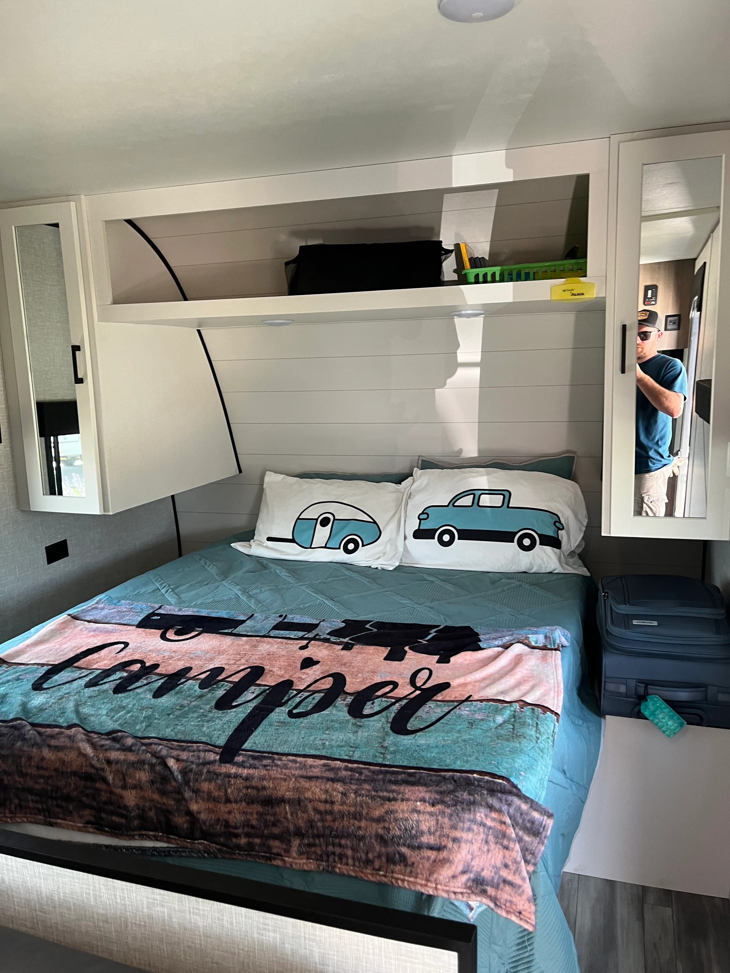 Queen bedroom with camper-print pillows and built-in wardrobe