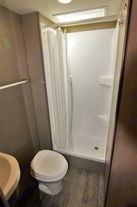 Shower stall with curtain next to the toilet in the bathroom