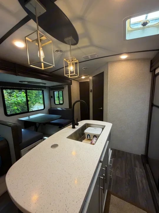 Kitchen island with sink and faucet, dinette and sofa visible beyond