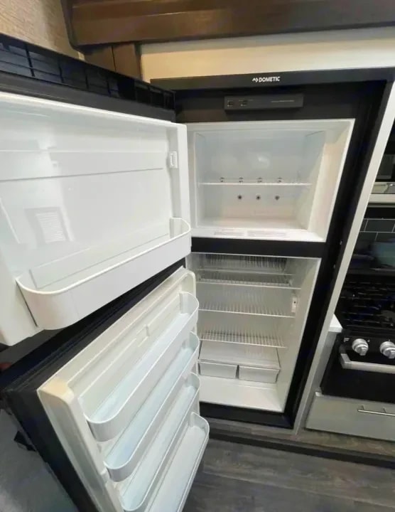 Open refrigerator and freezer compartment beside the stove