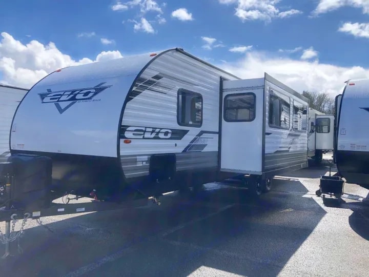 Three-quarter exterior view of the Evo trailer parked in a dealer lot beside other units