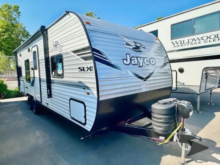 Three-quarter exterior view of the trailer showing the Jayco SLX graphics and full profile in sunlight