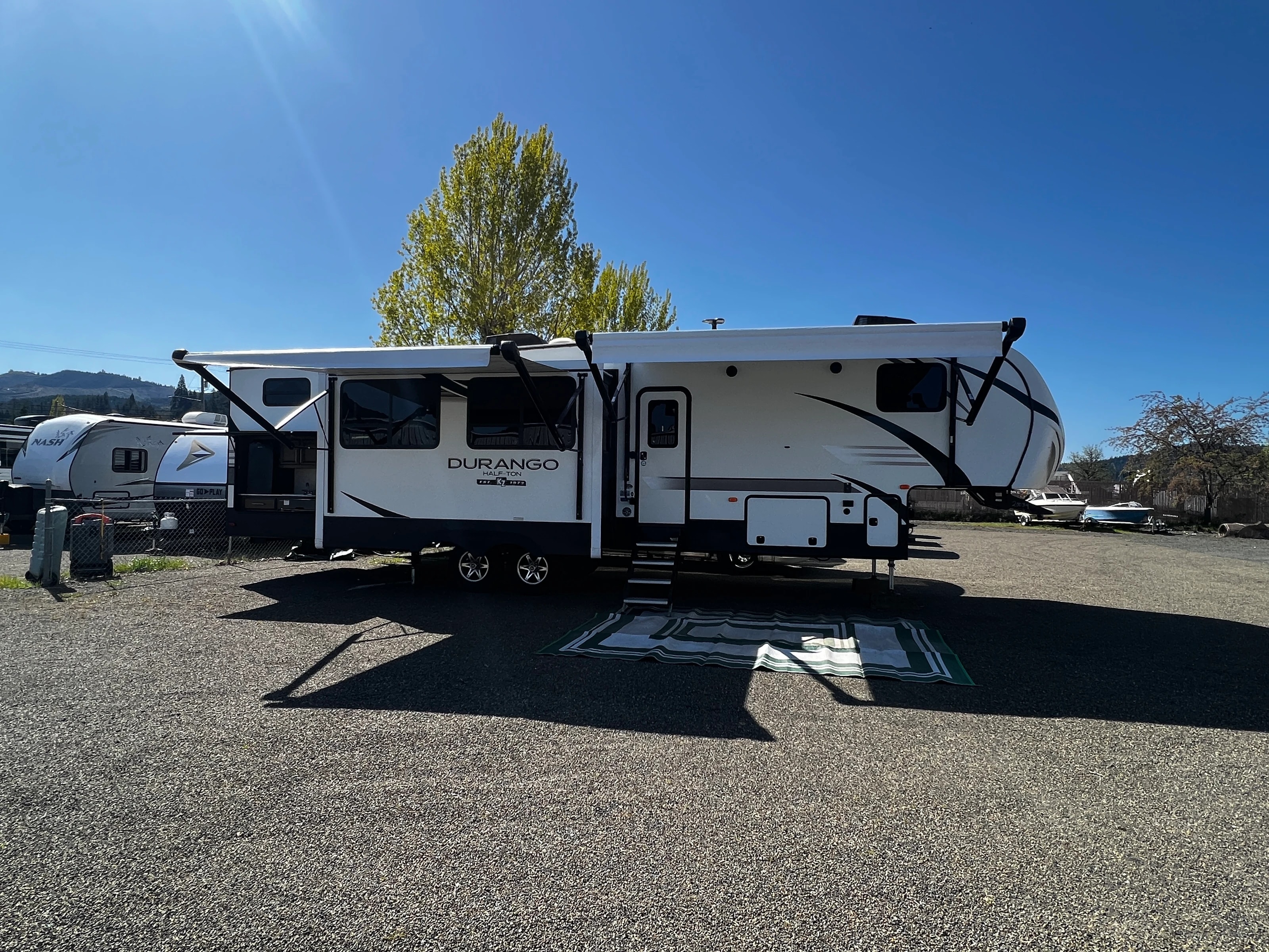 Three-quarter exterior view with both awnings extended on a sunny day