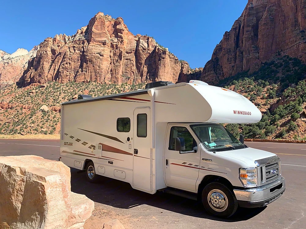 Three-quarter exterior view of the Winnebago Outlook parked before red rock cliffs