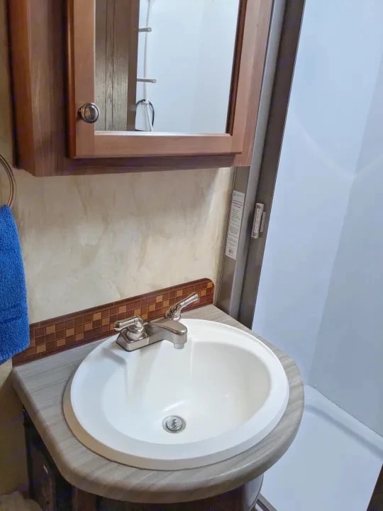 Bathroom sink with mirrored cabinet and tile backsplash