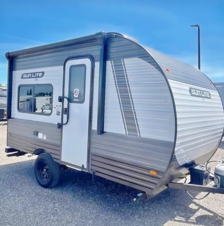 Three-quarter front view of the travel trailer with door and side window