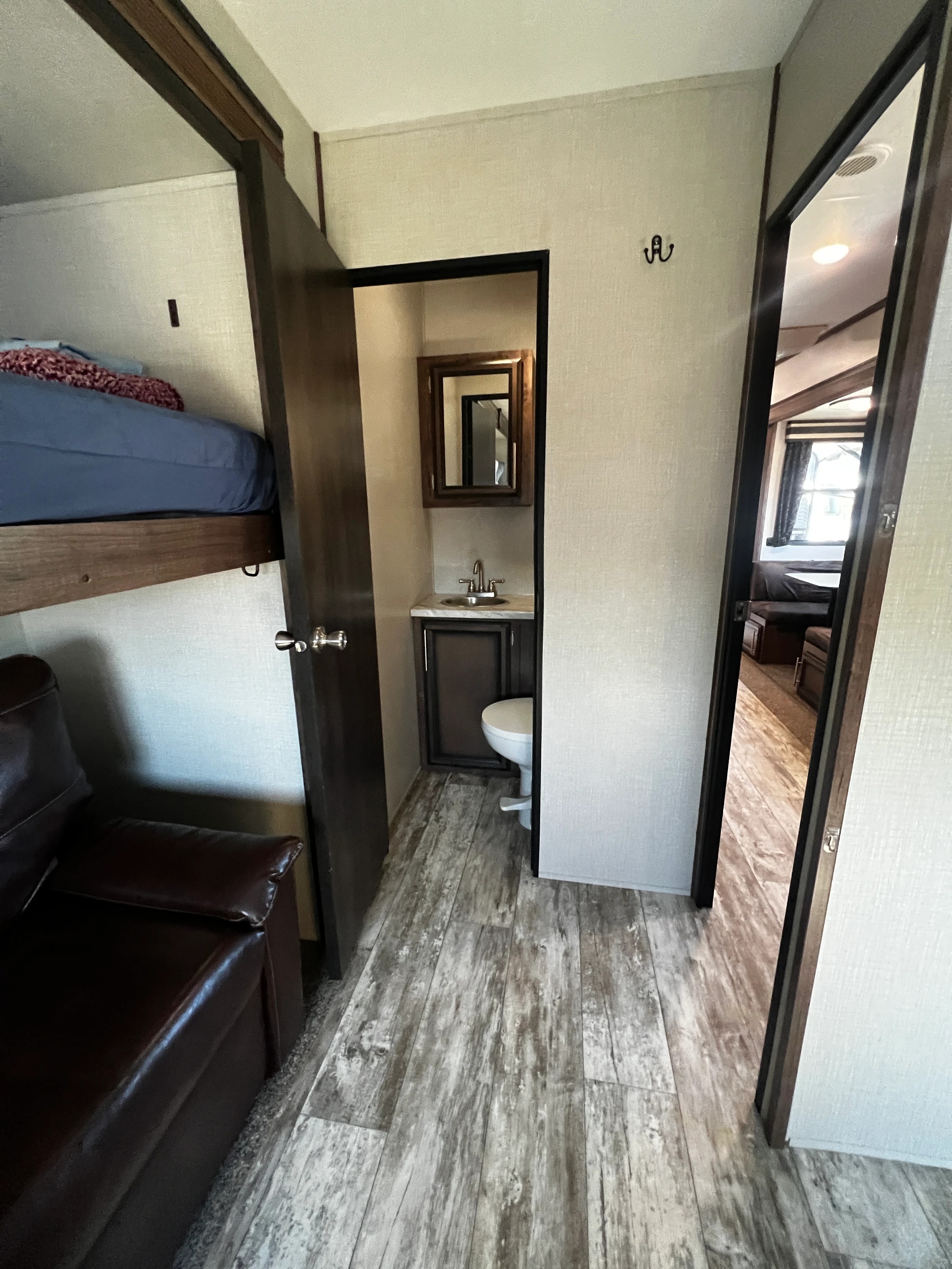 Hallway view showing the bunk room, half bath, and living area beyond