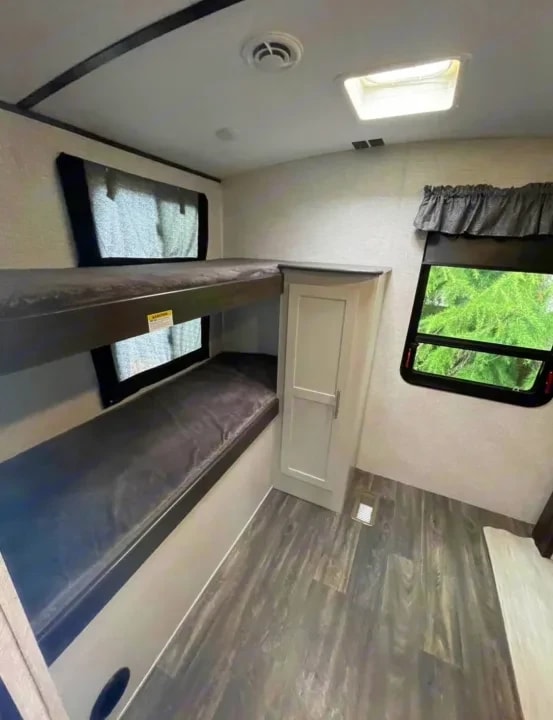 Bunkhouse with two stacked bunk beds and a small closet cabinet between them