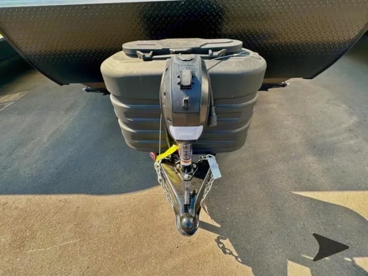Close-up of the hitch coupler, safety chains, and propane tank covers