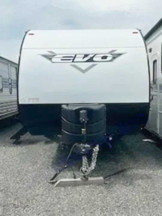 Front exterior view showing the Evo badge, propane tanks, and hitch with safety chains