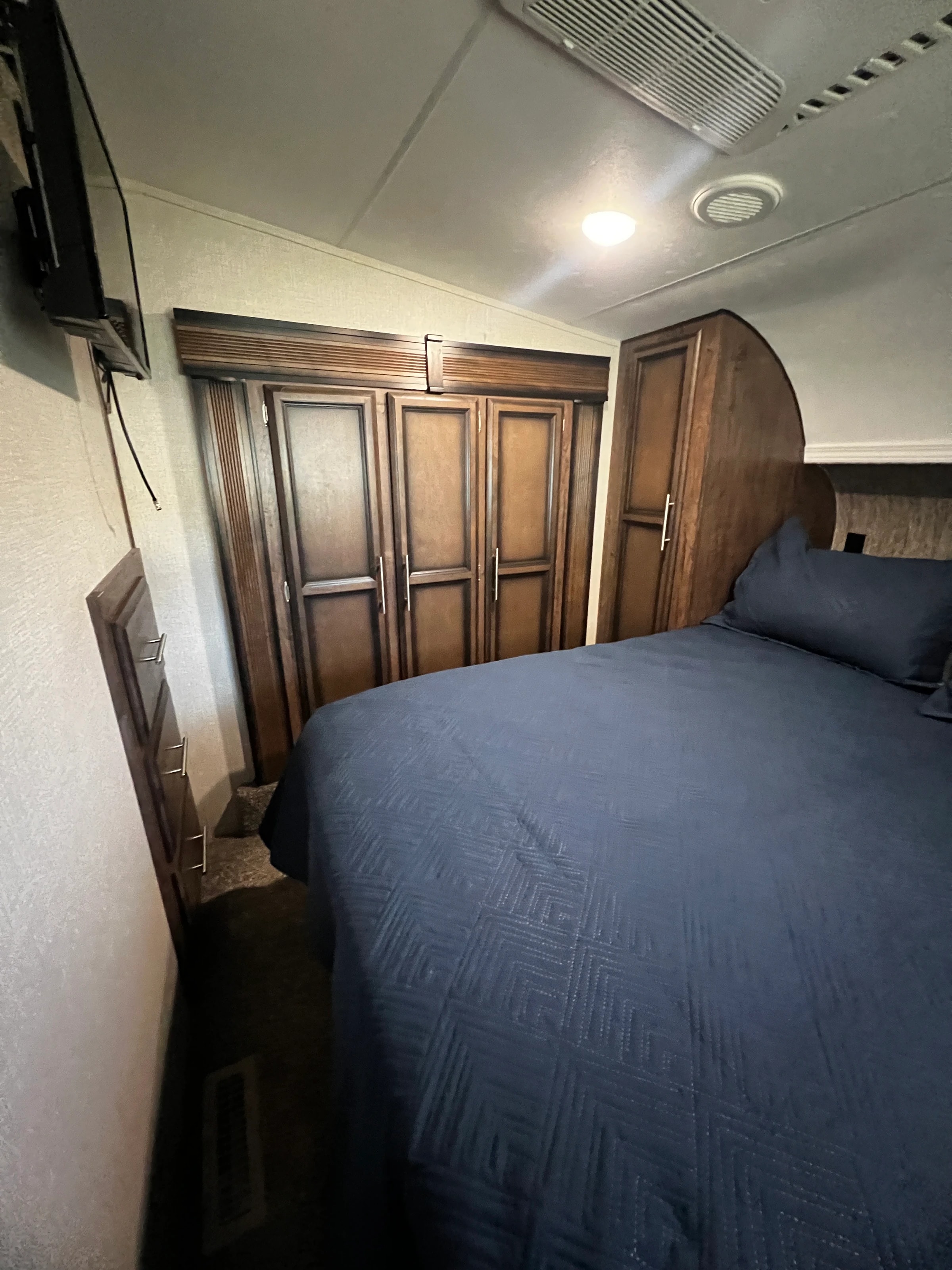 Primary bedroom with wardrobe cabinets and bed, alternate angle