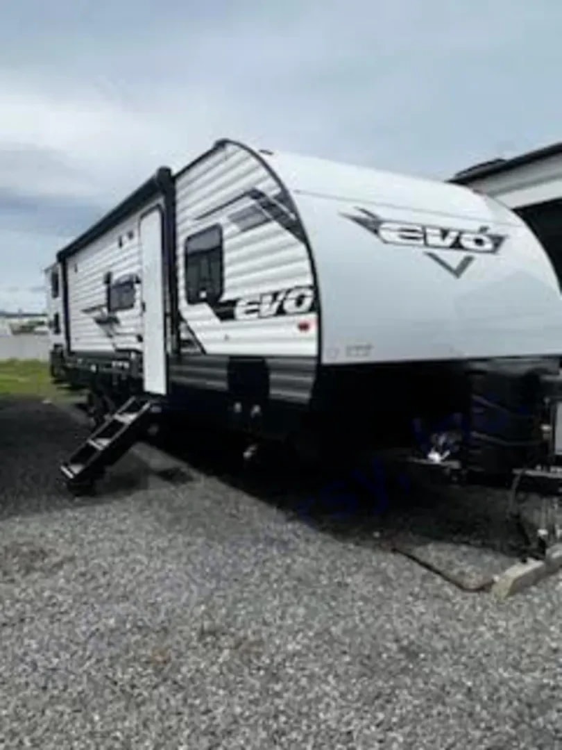 Three-quarter exterior view of the Evo travel trailer with entry door and steps down