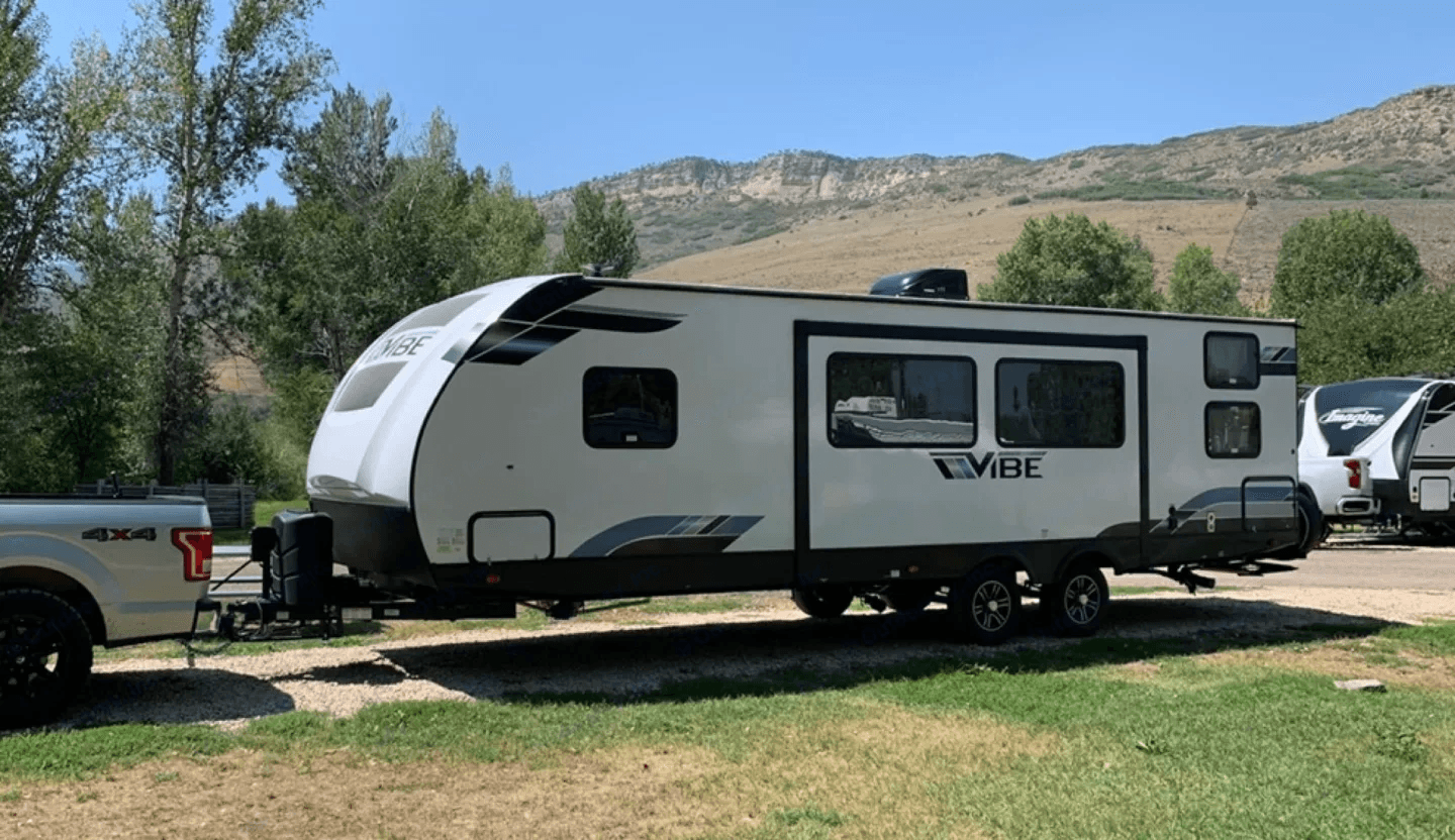 Camper hitched to a pickup with mountains behind