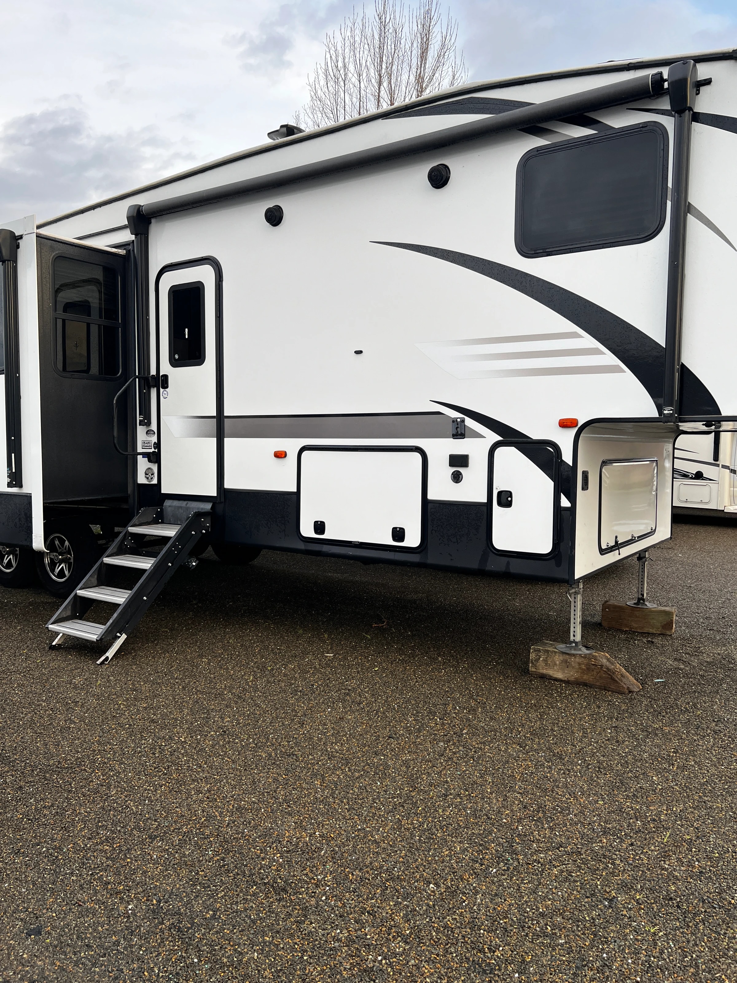Exterior side view with entry steps down and pass-through storage door open