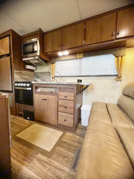 Kitchen counter, stove, and sofa seating with an area rug on the floor