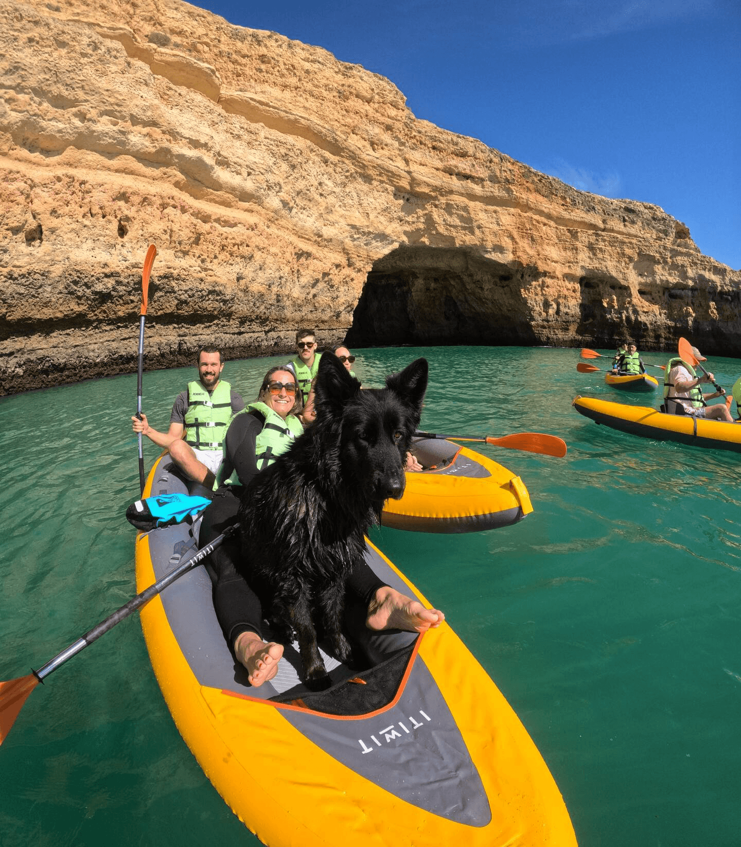 Tandem kayaks beneath sandstone cliffs
